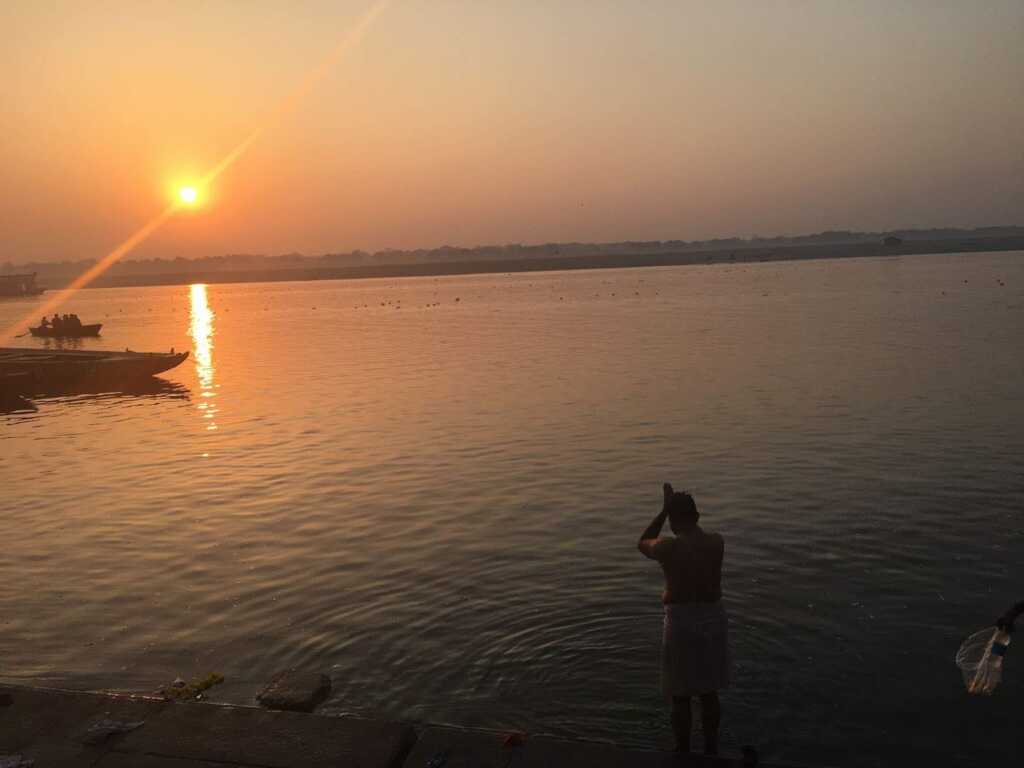  ガンジス川に浮かぶ朝日と沐浴する地元民
